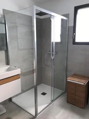 a glass shower in a bathroom with a sink at Superbe appartement T3 face mer baie Ajaccio in Pietrosella