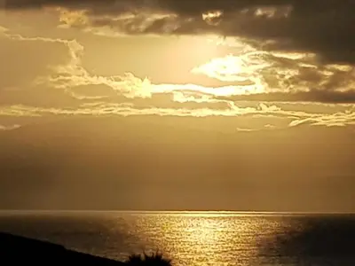 a sunset over the ocean with the sun in the sky at JACUZZI AJACCIO ENTRE MER ET MONTAGNE 200m DES PLUS BELLES PLAGES in Ajaccio