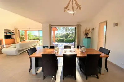 a dining room with a wooden table and chairs at Villa La Tour de Pinarello in Mangialla