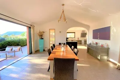 a dining room with a table and a kitchen at Villa La Tour de Pinarello in Mangialla