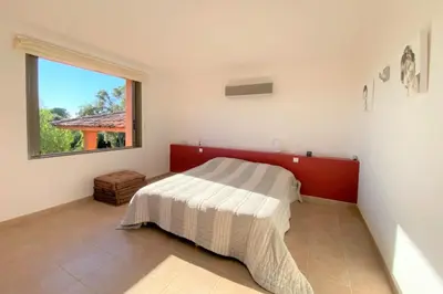 a bedroom with a bed and a window at Villa La Tour de Pinarello in Mangialla