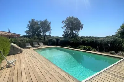 a swimming pool on a wooden deck next to a wooden deck at Villa La Tour de Pinarello in Mangialla