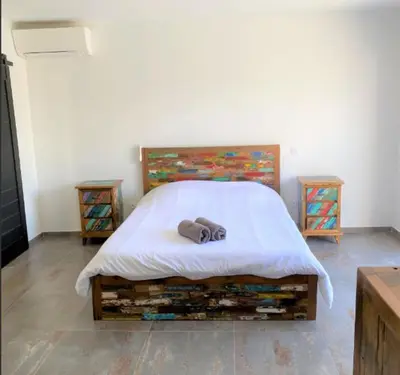 a bed with a white blanket and two night stands at Villa Montinu Di Caramontinu in Sainte-Lucie de Porto-Vecchio