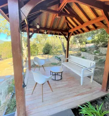a wooden deck with a bench and chairs on it at Villa Montinu Di Caramontinu in Sainte-Lucie de Porto-Vecchio