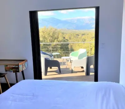 a bedroom with a bed and a view of a balcony at Villa Montinu Di Caramontinu in Sainte-Lucie de Porto-Vecchio
