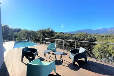 a deck with chairs and tables and a swimming pool at Villa Montinu Di Caramontinu in Sainte-Lucie de Porto-Vecchio