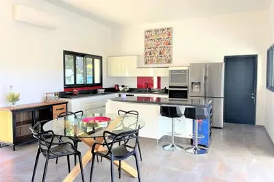 a kitchen with a glass table and black chairs at Villa Montinu Di Caramontinu in Sainte-Lucie de Porto-Vecchio