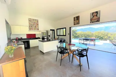 a kitchen and dining room with a table and chairs at Villa Montinu Di Caramontinu in Sainte-Lucie de Porto-Vecchio
