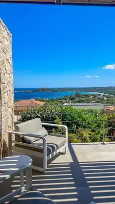 a patio with a bench and a view of the ocean at Villa Caramontinu in Sainte-Lucie de Porto-Vecchio