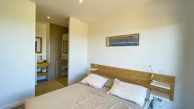 a bedroom with a bed with a wooden headboard at Villa Caramontinu in Sainte-Lucie de Porto-Vecchio