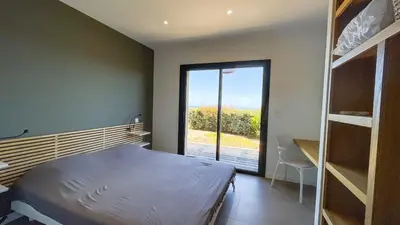 a bedroom with a bed and a large window at Villa Caramontinu in Sainte-Lucie de Porto-Vecchio