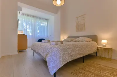a bedroom with a bed and a large window at Appartement refait à neuf, proche plage et centre ville- Ajaccio-Parc Berthaut in Ajaccio