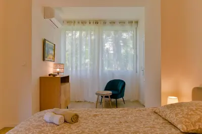a bedroom with a bed and a desk and a window at Appartement refait à neuf, proche plage et centre ville- Ajaccio-Parc Berthaut in Ajaccio