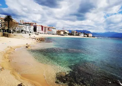 a view of a beach with buildings and the ocean at Appartement refait à neuf, proche plage et centre ville- Ajaccio-Parc Berthaut in Ajaccio