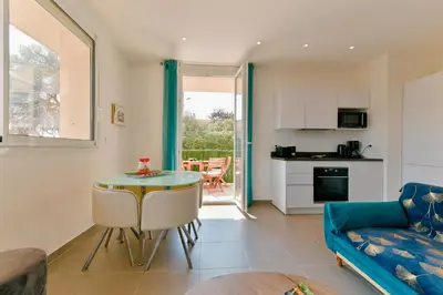 a living room with a table and a blue couch at Appartement refait à neuf, proche plage et centre ville- Ajaccio-Parc Berthaut in Ajaccio