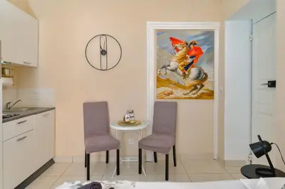 a kitchen with a table and two chairs and a painting at Studio rénové Hyper Centre- Ajaccio in Ajaccio