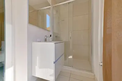 a white bathroom with a sink and a shower at Studio rénové Hyper Centre- Ajaccio in Ajaccio