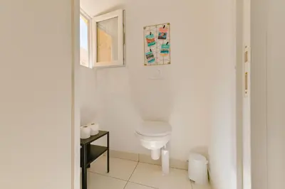 a white bathroom with a toilet and a window at Studio rénové Hyper Centre- Ajaccio in Ajaccio