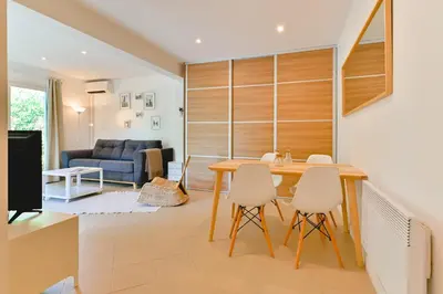a kitchen and living room with a table and chairs at Charmant Appartement - Jardinet Privé - 5 minutes des plages Sanguinaires - Ajaccio in Ajaccio