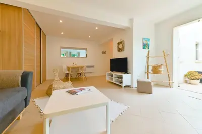 a living room with a couch and a table at Charmant Appartement - Jardinet Privé - 5 minutes des plages Sanguinaires - Ajaccio in Ajaccio