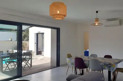 a dining room and living room with a table and chairs at Villa Rossa 6 pers dans résidence avec piscine chauffée privée in Lecci