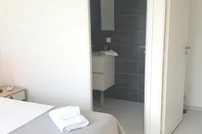 a bathroom with a shower and a bed in a room at Villa Rossa 6 pers dans résidence avec piscine chauffée privée in Lecci
