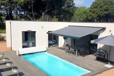 a swimming pool with a table and an umbrella at Villa Rossa 6 pers dans résidence avec piscine chauffée privée in Lecci