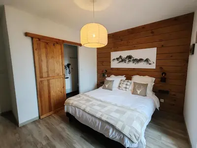 a bedroom with a bed with a wooden wall at Chambre d'hôtes casa di l'apa in Venaco