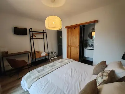 a bedroom with a white bed and a pendant light at Chambre d'hôtes casa di l'apa in Venaco