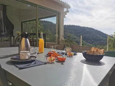 a table with food and a bottle of wine on it at Chambre d'hôtes casa di l'apa in Venaco