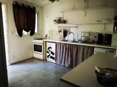 a kitchen with a sink and a stove top oven at Maison de village avec jardin privatif in Zicavo