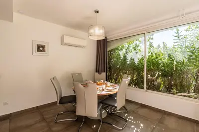 a dining room with a table and chairs and a large window at Les Arcades de Cala Rossa in Lecci
