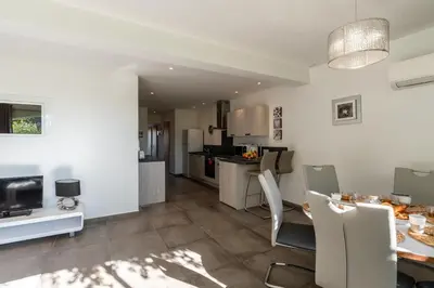 a kitchen and living room with a table and chairs at Les Arcades de Cala Rossa in Lecci