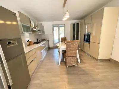 a kitchen with a table and a dining room at Les jardins de Funtanone in Vignale