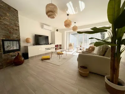 a living room with a couch and a tv at Les jardins de Funtanone in Vignale