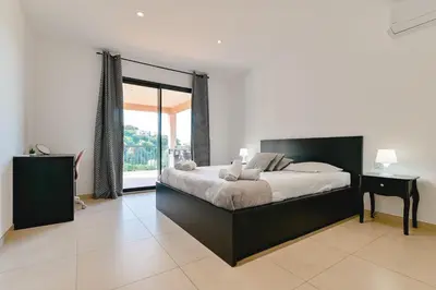 a bedroom with a large bed and a window at Villa Terrasse et Piscine à l'entrée de Porticcio in Cauro