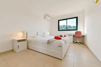 a bedroom with a white bed with a red teddy bear on it at Villa Terrasse et Piscine à l'entrée de Porticcio in Cauro