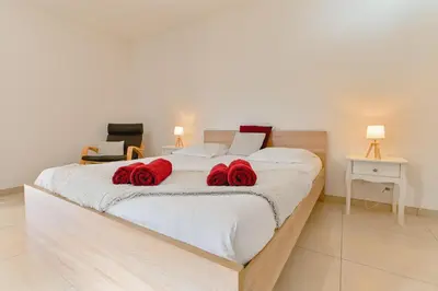 a bedroom with a large bed with red roses on it at Villa Terrasse et Piscine à l'entrée de Porticcio in Cauro