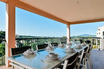 a long table on a balcony with a view at Villa Terrasse et Piscine à l'entrée de Porticcio in Cauro