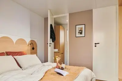 a bedroom with a bed with a book on it at Camping l'Oso in Porto-Vecchio