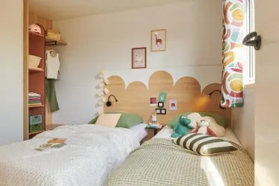 a childs bedroom with two beds and a headboard at Camping l'Oso in Porto-Vecchio
