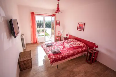 a bedroom with a red bed and a window at U Paradisu - Villa 10/12 pers avec piscine privée in Alata
