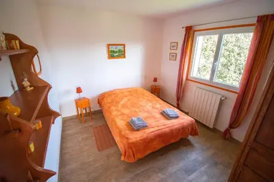 a bedroom with a bed and a large window at U Paradisu - Villa 10/12 pers avec piscine privée in Alata