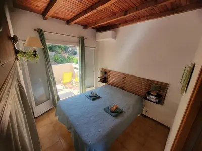 a bedroom with a bed and a large window at Casa Lova in Propriano