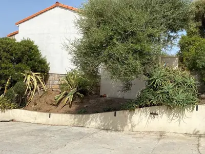 a retaining wall with plants in front of a house at Casa Lova in Propriano