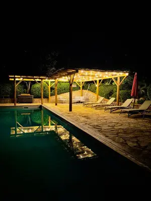 a swimming pool at night with a pavilion and chairs at Villa à Conca avec piscine pour 8 personnes en Corse du Sud in Conca