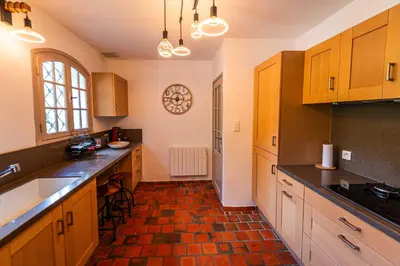 a kitchen with wooden cabinets and black counter tops at Villa à Conca avec piscine pour 8 personnes en Corse du Sud in Conca