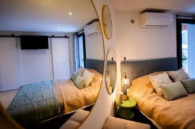 a small room with two beds and a mirror at Villa à Conca avec piscine pour 8 personnes en Corse du Sud in Conca