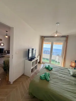 a bedroom with a bed with a television and a window at Bagnu di sole - sur la route des îles sanguinaires adorable T2 vue mer in Ajaccio