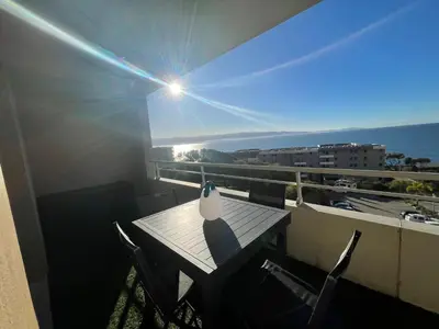 a table and chairs on a balcony with a view of the ocean at Bagnu di sole - sur la route des îles sanguinaires adorable T2 vue mer in Ajaccio